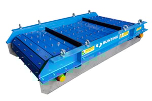 Overband magnet removing ferrous metal from material on a conveyor in plastics recycling